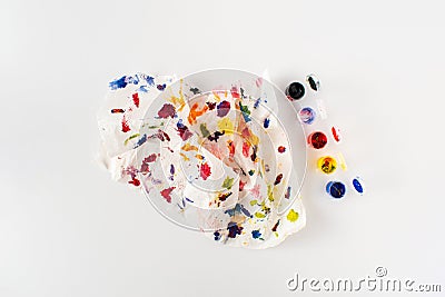 Crumpled paper splattered with vibrant multicolor paint on clean white background. Minimal composition. Artistic colorful idea. Stock Photo