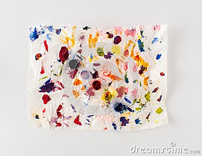 Crumpled paper splattered with vibrant multicolor paint on white background. Minimal abstract colorful idea. Flat lay Stock Photo