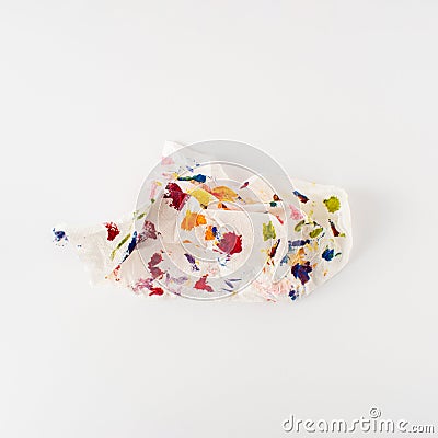 Crumpled paper splattered with vibrant multicolor paint on white background. Minimal composition. Artistic colorful idea Stock Photo