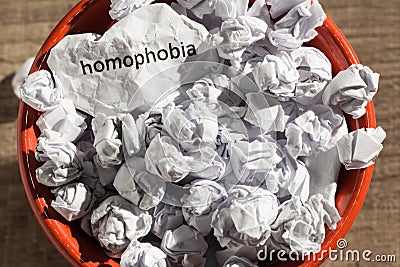 Crumpled paper written homophobia inside the trash can. Paper ba Stock Photo