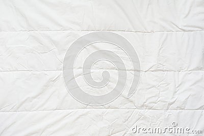 Crumpled quilt white blanket texture. Close up. Stock Photo