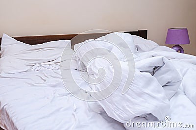 Crumpled white bedding on the bed in the bedroom Stock Photo