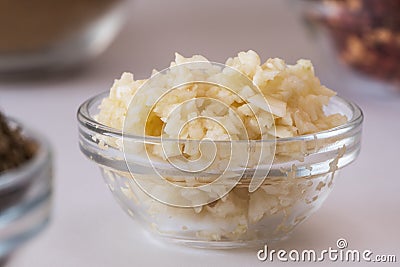 Crushed Garlic in glass bowl. Healthy Food Concept Stock Photo