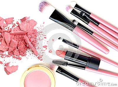 Crushed make up powder and lipstick samples with brushes on white background. Stock Photo