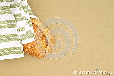 Crusty golden sesame seed loaf in a cloth Stock Photo