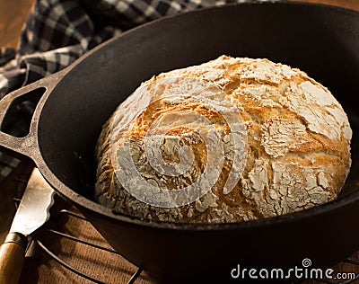 Crusty round loaf of French bread in cast iron dutch oven Stock Photo