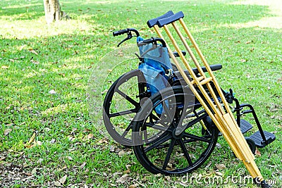 The crutches lean against the wheelchair Stock Photo