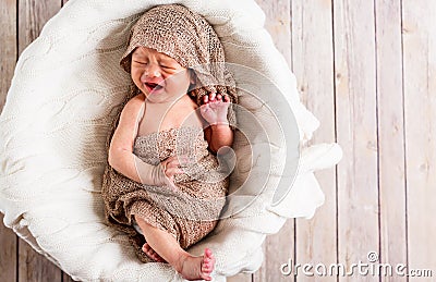 Crying baby boy in a basket Stock Photo