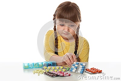 Crying little child with many different pills. Danger of medicament intoxication Stock Photo