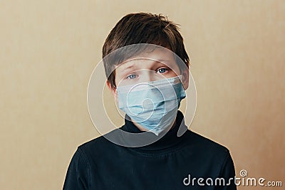A crying teenager in a face mask looks at the camera and worries about the consequences of the coronavirus epidemic. Depression du Stock Photo
