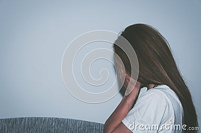 Crying woman abused as young feeling depressed and miserable while she sitting alone in her room Stock Photo