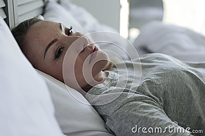 Crying woman lying in bedroom Stock Photo