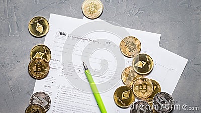 Crypto currency: Pages of the tax form 1040 and a scatter of coins bitcoin, ethereum. Editorial Stock Photo