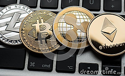 Cryptocurrencies Ethereum, Ripple, Bitcoin and Litecoin coins on computer laptop keyboard. Editorial Stock Photo