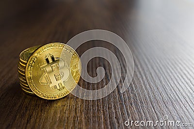 Cryptocurrency. Bitcoin virtual money. Golden coin on wooden table Stock Photo
