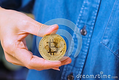 Cryptocurrency coins - Bitcoin, Ethereum, Litecoin, Ripple. Women hold the cryptocurrency coin on hand. Physical bitcoins gold and Stock Photo