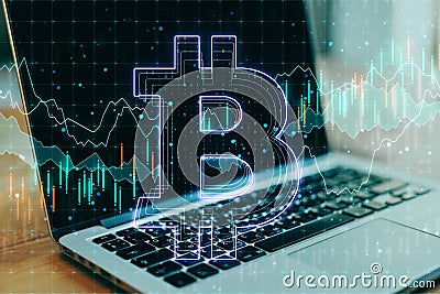 Cryptocurrency concept with laptop and bitcoin sign at business chart screen Editorial Stock Photo