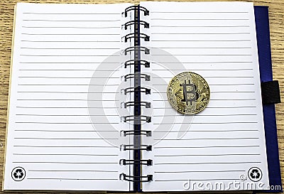 Cryptocurrency physical golden bitcoin. Golden bitcoin on notebook background Stock Photo