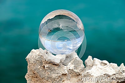 Crystal ball on the rock on the blue background Stock Photo