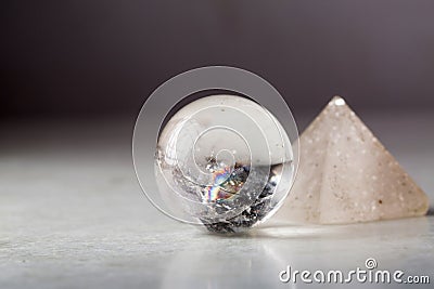 Crystal ball and rock crystal pyramid against a dark background Stock Photo