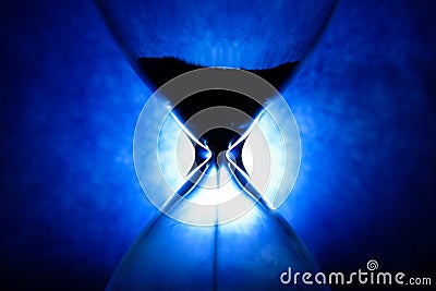 Crystal Hourglass on blue background, inspirational time pass concept Stock Photo