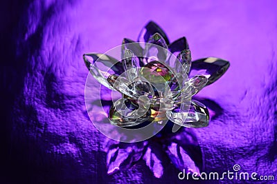 Crystal lotus on rich dark purple shiny table with light reflection. Sahasrara chakra symbol Stock Photo