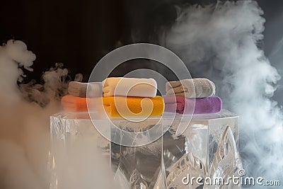 crystal podium with an assortment of luxury washcloths, warm steam around Stock Photo