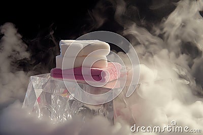 crystal podium with an assortment of luxury washcloths, warm steam around Stock Photo