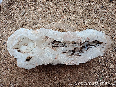 Crystal stone on the sand, textured background. natural stone, rare semiprecious. wallpaper, sea ,ocean. Stock Photo