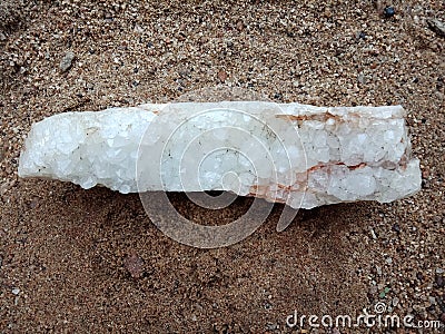 Crystal stone on the sand, textured background. natural stone, rare semiprecious. wallpaper, sea ,ocean. Stock Photo