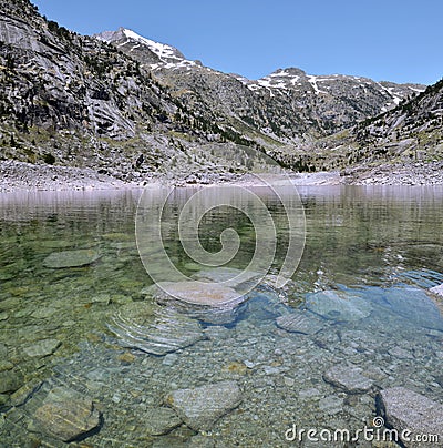 Crystalline water of Estany de Cavallers Lake Stock Photo