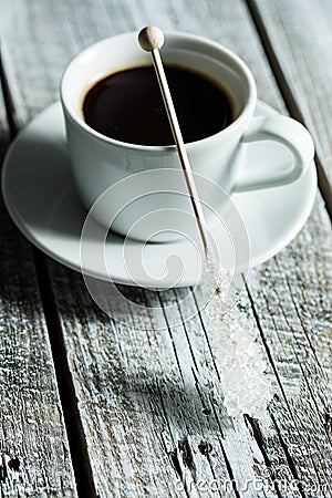 Crystallized sugar on wooden stick and coffee cup. Stock Photo