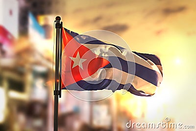Cuba Flag Against City Blurred Background At Sunrise Backlight Stock Photo
