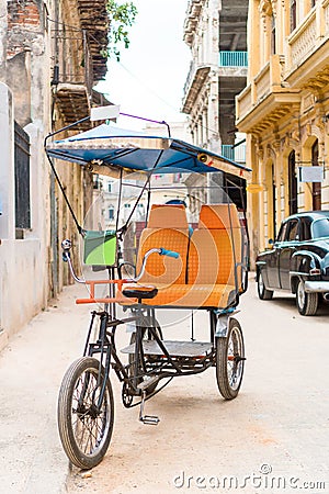 Cuban taxi bicycle parked in front of colorful colonial houses Stock Photo