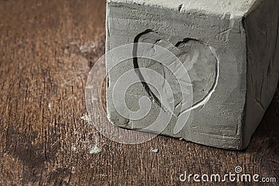 Cube with clay heart on wooden surface Stock Photo