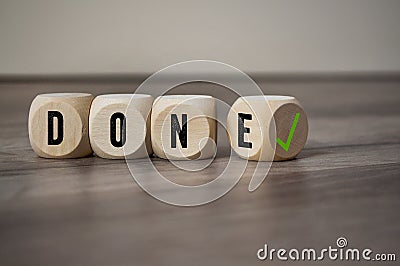 Cube and dice with word done and green checkmark on wooden background Stock Photo