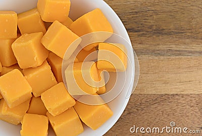 Cubed mild cheddar cheese in a white bowl Stock Photo