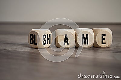 Cubes, blocks or dice with blame and shame on wooden background Stock Photo
