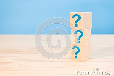 Cubes with blue question marks on wooden background, closeup. Space for text. Wooden cubes with question marks on wood table. FAQ Stock Photo