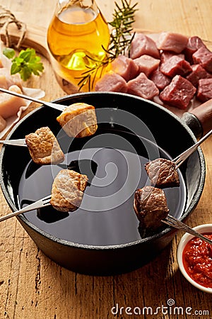 Cubes of cooked meat over pot of oil Stock Photo