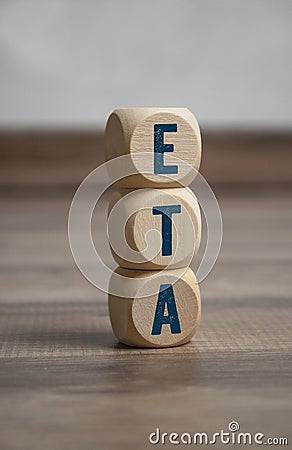 Cubes and dice with ETA Estimated time of arrival on wooden background Stock Photo