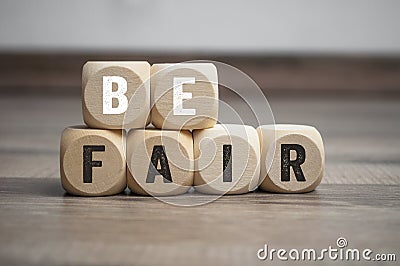 Cubes and dice with message Be fair on wooden background Stock Photo