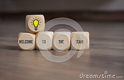 Cubes and dice on wooden background with the message welcome to the team Stock Photo