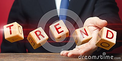 Cubes thrown by a man make up word Trend. Predicting the popularity of new themes, styles and technologies in next season. Stock Photo
