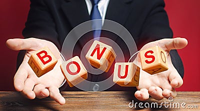 Cubes thrown by a man make word BONUS. Receive bonuses, rewards and preferences. A nice addition. Salary increase, wage premium Stock Photo