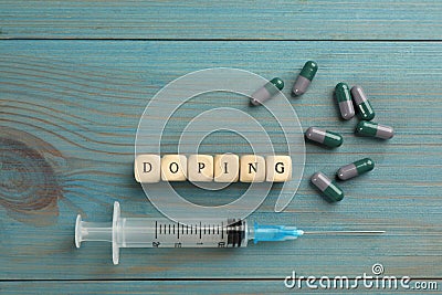 Cubes with word Doping and drugs on light blue wooden background, flat lay Stock Photo