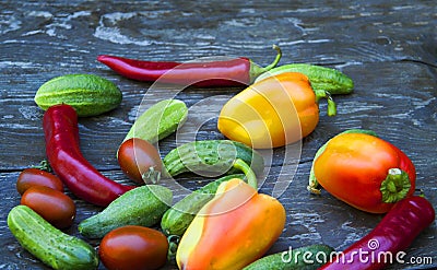 Cucumbers, tomatoes, peppers, on a wooden table Stock Photo