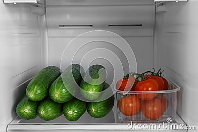 Cucumbers and tomatoes in refrigerator Stock Photo