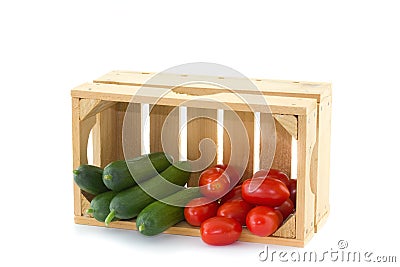 Cucumbers and tomatoes in a wooden crate Stock Photo