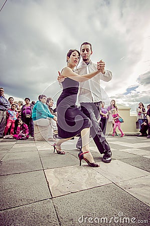 Cuenca, Ecuador - April 22, 2015: Couple performing latin dance styles on city square in front of small crowd Editorial Stock Photo